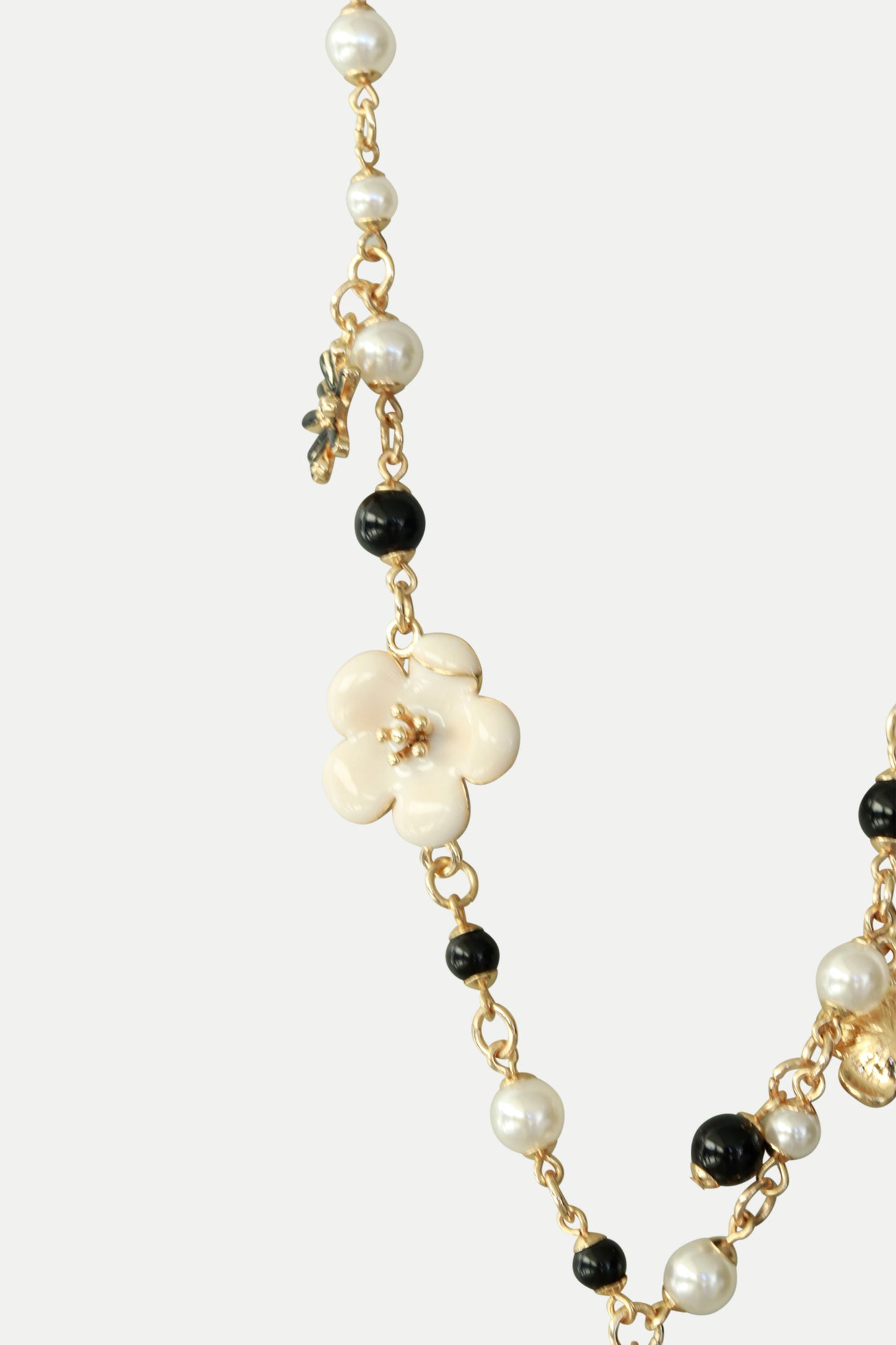 Lange Kette mit Perlen und Blumenapplikationen